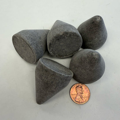 A few pieces of EF-1000 CN 01 Eco-Flex™ cone-shaped media shown with a penny for size comparison